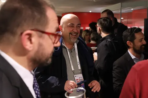 Gianfranco Ursino e Marco Tullio Giordano ridono con altri ospiti durante l’aperitivo di networking di Casa Sanremo Invest 2024.