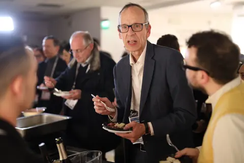 Massimo Chiriatti conversa con altri ospiti al buffet dell’aperitivo di Casa Sanremo Invest 2024.