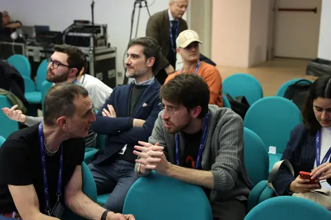 Partecipanti si scambiano idee tra le file della platea.