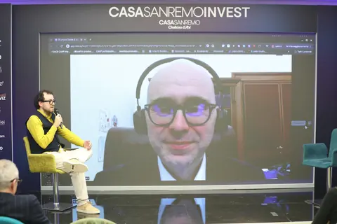 Il deputato Giulio Centemero interviene in video collegamento sul palco di Casa Sanremo Invest 2026.